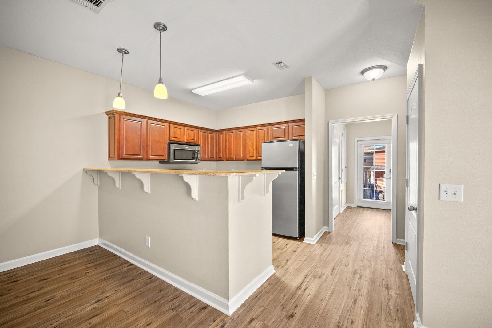Kitchen breakfast bar with pendant lights opening to the living area