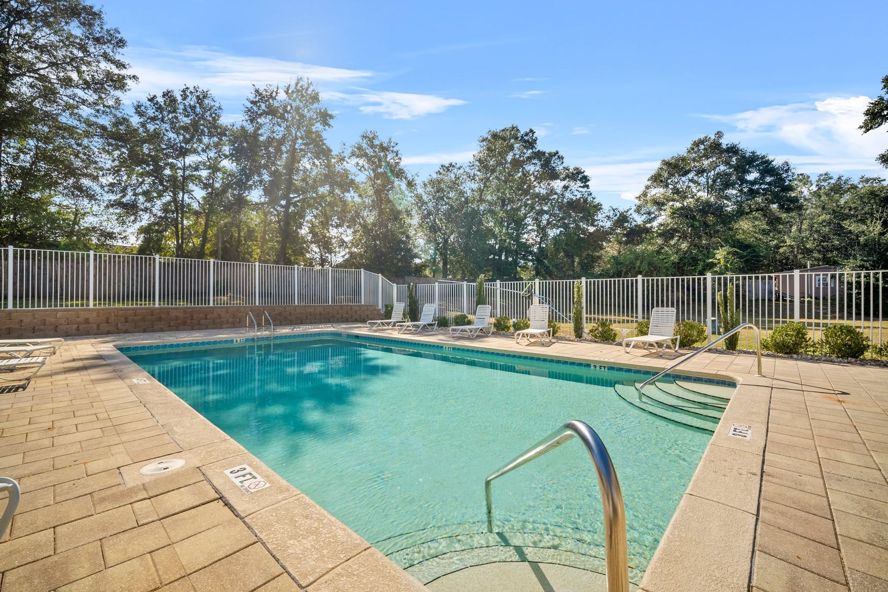 Community pool with lounge chairs and shallow-entry steps